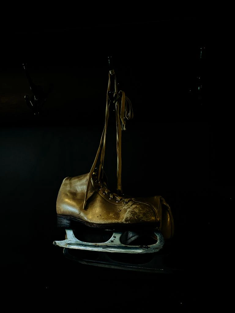 An open reference encyclopedia beside a magnifying glass on a dark wooden desk